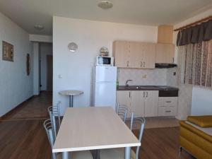 a kitchen with a table and a white refrigerator at Apartments with parking space Igrane, Makarska - 13535 in Igrane +16 photos