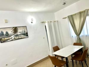 a dining room with a white table and chairs at Résidence Saphir-Korhogo in Korhogo