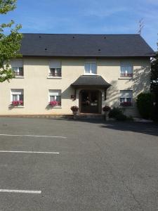 a large tan building with windows and a door at Hotel Restaurant Le Bourgneuf in Morlaas