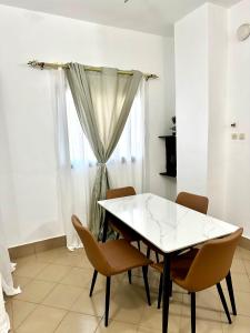 a dining room with a white table and chairs at Résidence Saphir-Korhogo in Korhogo +3 photos