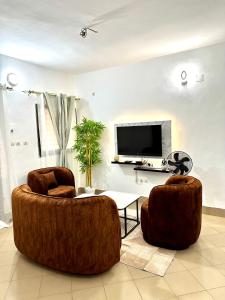 a living room with two chairs and a tv at Résidence Saphir-Korhogo in Korhogo