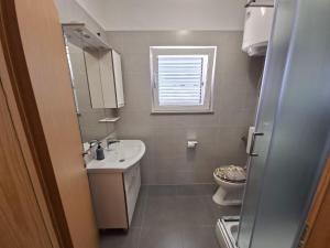 a bathroom with a sink and a toilet at Apartments with parking space Vrsi, Zadar - 15944 in Vrsi +24 photos