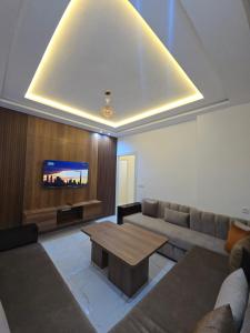 a living room with a couch and a table and a tv at Plage & Confort in Fnidek
