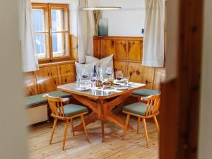 a wooden table with chairs and wine glasses on it at Tirola Hütte in Alpbach +32 photos