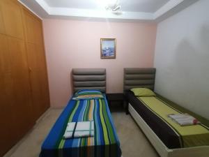 a room with two twin beds in a room at Appartement S3 Haut Standing 141m2 Connecté avec Fibre - 7-10 min Aéroport in Burj at Turkī