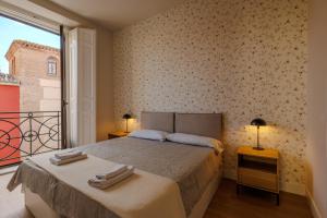 a bedroom with a bed and a large window at apartamentos catedral suite in Ávila +18 photos