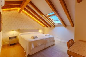 a bedroom with a bed and a skylight at apartamentos catedral suite in Ávila