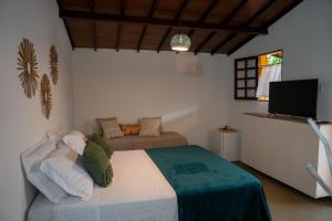 a bedroom with a bed and a television in it at Pousada Estação Cajueiro in São Miguel do Gostoso +54 photos