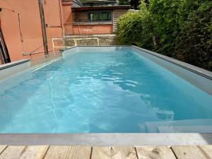 a swimming pool with blue water in a backyard at Aux Berges du Lac in Jalhay