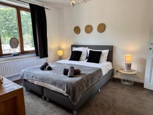 a bedroom with a bed with two teddy bears on it at Aux Berges du Lac in Jalhay +45 photos