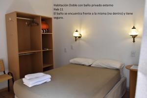 a bedroom with a bed with two towels on it at Hotel Frossard in Buenos Aires