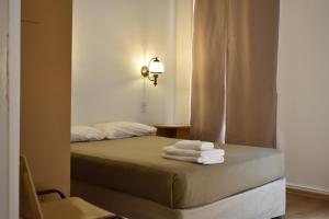 a bedroom with a bed with towels on it at Hotel Frossard in Buenos Aires