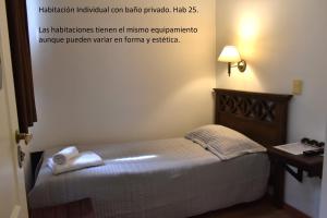 a small bed in a room with a sign on the wall at Hotel Frossard in Buenos Aires