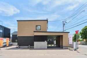 a building with a parking lot with a garage at 藤乃宿 Villa Moere モエレ沼公園すぐ 愛犬と一緒に泊まれる新築1棟貸し in Sapporo