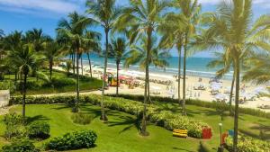 a view of the beach from the balcony of a resort at Sussurros do Mar in Bertioga