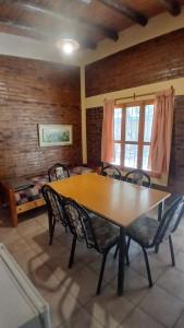a dining room with a wooden table and chairs at Cabañas fenix alojamiento in San Rafael