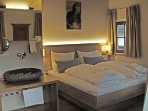 a bedroom with a large bed and a sink at Mammhofer Suite & Breakfast in Oberammergau