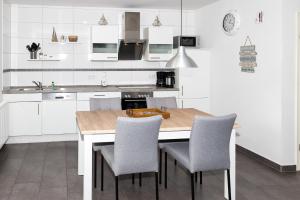 a kitchen with white cabinets and a wooden table and chairs at Residenz Cuxhaven Döse, Ankerplatz in Döse
