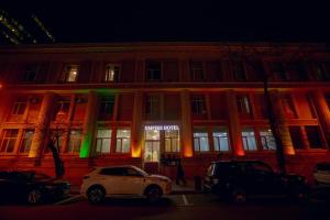 a white car parked in front of a building at night at Empire Hotel Baku F1 view in Baku