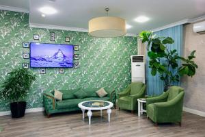 a living room with green couches and a tv at Empire Hotel Baku F1 view in Baku