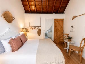 a bedroom with a white bed and a table at Sintra Center Guest House Escape to Nature in Sintra