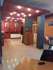 a lobby with red walls and a table and a podium at Pensiunea Casa Raul in Cluj-Napoca