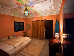a bedroom with a bed and a coffered ceiling at Farissi's Zawya Surf House in Aourir