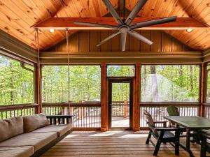 a living room with a couch and a ceiling fan at Hot Tub Cabin + Screened Porch | Red River Gorge in Beattyville