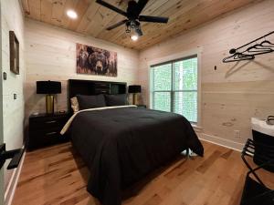 a bedroom with a bed and a ceiling fan at Hot Tub Cabin + Screened Porch | Red River Gorge in Beattyville