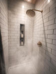 a shower with a shower head in a bathroom at Hot Tub Cabin + Screened Porch | Red River Gorge in Beattyville +43 photos
