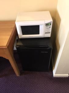 a microwave oven sitting on top of a black cabinet at Relax Inn in Wilkes-Barre