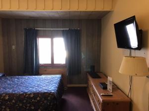 a hotel room with a bed and a television at Relax Inn in Wilkes-Barre