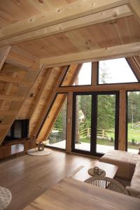 a living room with wooden ceilings and large windows at Ninas Villas in Vrela