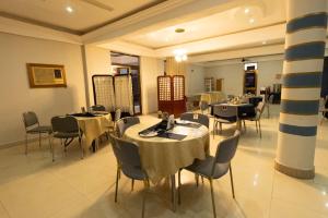 a dining room with tables and chairs in a restaurant at GLAMOSSAY HOTEL LIMITED SUNYANi in Abesem