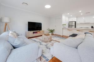 a living room with two white couches and a kitchen at Kookora Suites in Griffith