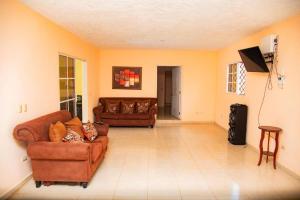 a living room with two couches and a flat screen tv at Boom Ranch in Palmarito