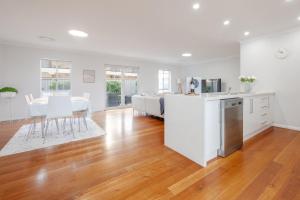 a kitchen and dining room with white cabinets and a table at Kookora Suites in Griffith