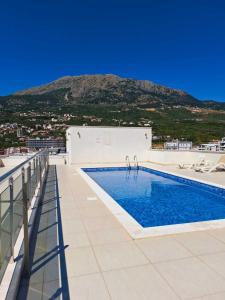 a swimming pool on top of a building with a mountain at Apart sunset in Bar