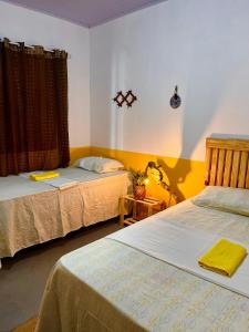 two beds in a room with yellow walls at Casa Amarílis - próxima a Atins in Barreirinhas