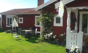 a red house with a table and chairs in the yard at Dagmarsgårdens Stuguthyrningen in Kullsbjörken