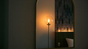 a lamp in a room next to a mirror at くらしホテル Hakodate in Hakodate +115 photos