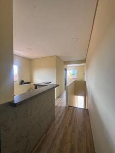 an empty room with a kitchen with a counter at Casa da Lu in Barreirinhas