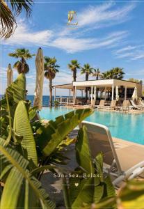 a resort with a swimming pool and palm trees at Joelle Premium Hotel in Sarandë
