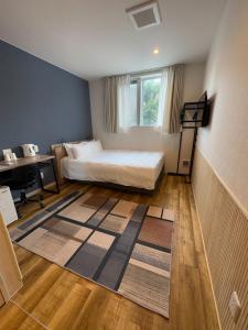 a bedroom with a bed and a desk in it at Megu Fuji 2021 in Fujiyoshida
