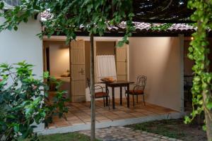a patio with a table and chairs on it at Pousada Estação Cajueiro in São Miguel do Gostoso