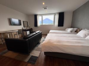 a hotel room with two beds and a couch at Megu Fuji 2021 in Fujiyoshida