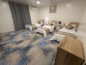 a room with three beds and a tv in it at شقق دانة ليالينا المخدومه in Al Namas +62 photos