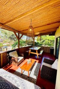 a porch with a wooden ceiling and a table at Apartamentos El Labrador in Tamarindo