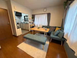a living room with a table and a couch at ゲストハウス あぽわん 貸切宿無料駐車場 in Mitoyo