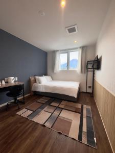 a bedroom with a bed and a desk and a window at Megu Fuji 2021 in Fujiyoshida